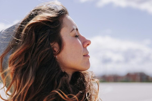 woman taking deep breath outside